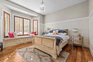 Bedroom with a chandelier and dark wood-type flooring