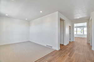 Carpeted empty room with a textured ceiling