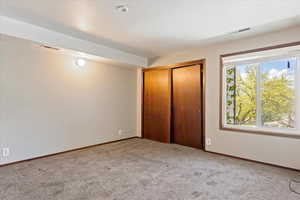 Unfurnished bedroom with carpet flooring and a closet