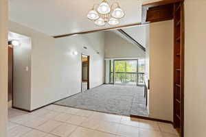 Interior space featuring a high ceiling, a notable chandelier, and light colored carpet