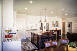 Kitchen with a center island, stainless steel appliances, backsplash, and dark hardwood / wood-style flooring