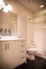 Full bathroom with shower / tub combo with curtain, toilet, and vanity