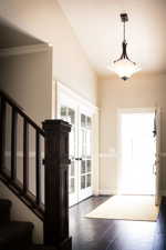Foyer entrance with vaulted ceiling, french doors, and dark wood-type flooring