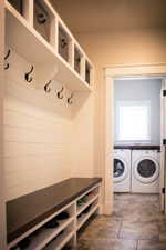 Mudroom with tile floors and separate washer and dryer