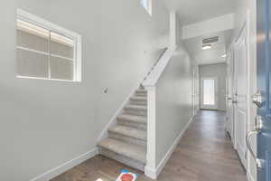 Staircase featuring a healthy amount of sunlight and hardwood / wood-style flooring