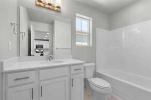 Full bathroom with shower / bath combination, toilet, and vanity