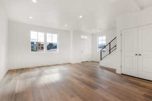 Unfurnished living room with beamed ceiling and wood-type flooring