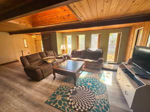 Living room with wooden ceiling, ceiling fan, beam ceiling, and hardwood / wood-style flooring