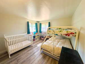 Bedroom with a textured ceiling and hardwood / wood-style floors