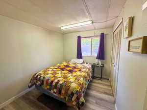 Bedroom with a closet, hardwood / wood-style flooring, and a textured ceiling