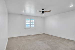 Empty room with carpet and ceiling fan