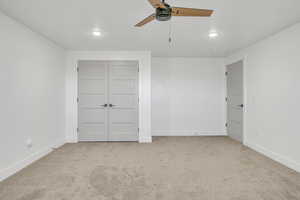 Unfurnished bedroom featuring light carpet, a closet, and ceiling fan