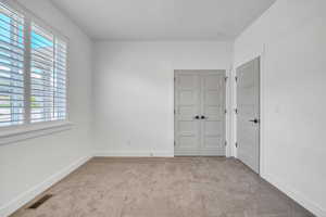 Unfurnished bedroom featuring light colored carpet