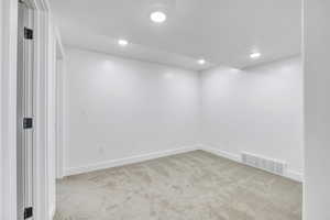 Unfurnished room featuring light carpet