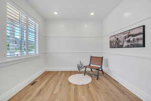 Sitting room featuring light wood-type flooring and crown molding