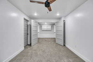 Unfurnished bedroom with light colored carpet and ceiling fan