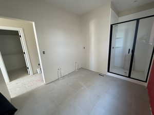 Primary bathroom featuring large tile flooring, shower, and separate tub