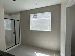 Primary bathroom, walk-in shower, tile floors, tile accent wall, and tub (not installed yet)