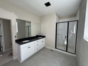 Primary bathroom with double vanity, quartz countertops, walk-in shower, tile floors, and soaking tub (not installed yet)