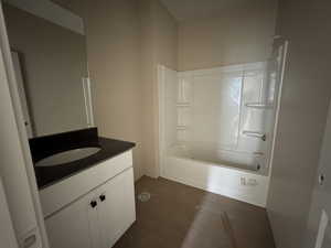 Full bath featuring vanity with quartz countertop, LVP floors, and tub / shower combination