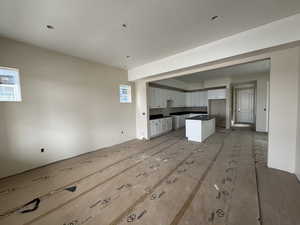 Kitchen with open floor plan, quartz countertops, white cabinets, and plenty of natural light