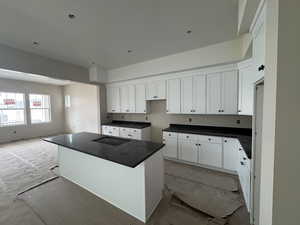 Kitchen with white cabinets, quartz countertops, and a center island