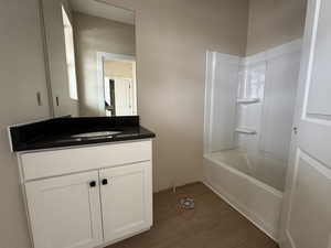 Full bath featuring vanity with quartz countertop, shower / bathtub combination, and LVP floors