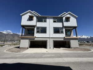 View of front of property featuring a garage, balcony, and mountain view