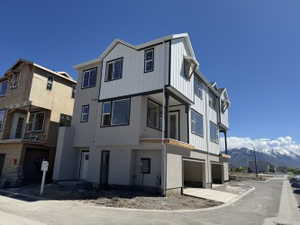 View of property featuring a garage, balcony, front door, and a mountain view