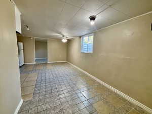 Basement with ceiling fan and white refrigerator