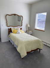 Carpeted bedroom featuring a baseboard heating unit