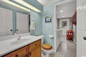 Bathroom featuring tile floors, vanity with extensive cabinet space, a textured ceiling, and toilet