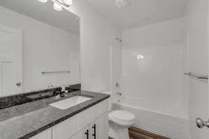 Full bathroom with shower / bathing tub combination, vanity, hardwood / wood-style floors, and toilet