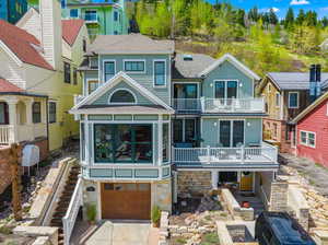 Back of property with a balcony and a garage