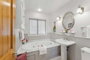 Bathroom with a bath, toilet, and tile patterned floors