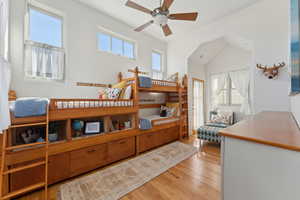 Bedroom featuring light wood-type flooring, ceiling fan, and vaulted ceiling