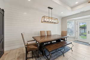 Dining room featuring a barn door, an inviting chandelier, and light hardwood / wood-style flooring