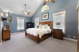 Bedroom with carpet, ceiling fan, and high vaulted ceiling