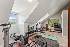 Workout room featuring carpet and vaulted ceiling