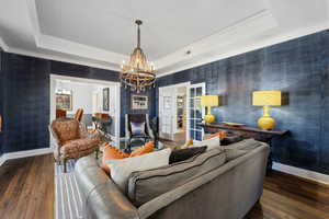 Living room with a tray ceiling and dark hardwood / wood-style flooring