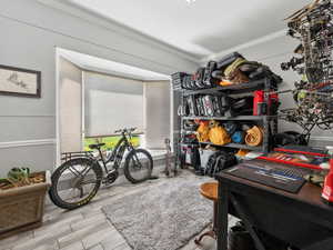 Office space featuring crown molding and light wood-type flooring