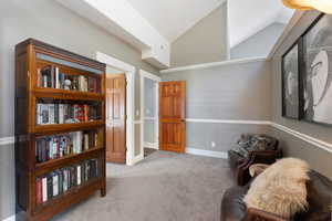 Living area with vaulted ceiling and carpet