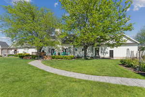 View of property hidden behind natural elements with a front yard