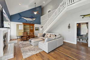 Living room with high vaulted ceiling, ceiling fan, and hardwood / wood-style floors