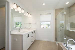 Bathroom featuring tile patterned flooring, separate shower and tub, and vanity