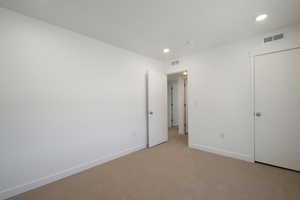 Unfurnished bedroom featuring light colored carpet