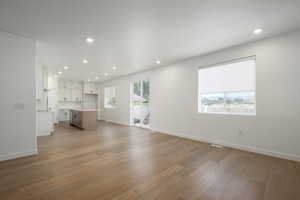 Unfurnished living room featuring light hardwood / wood-style floors and sink