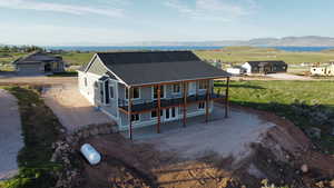 View of front of property with driveway, roof with shingles, a patio area, and a mountain view