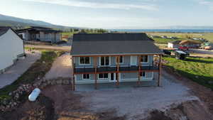 View of front facade with roof with shingles, a patio area, and a mountain view