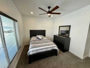 Bedroom with ceiling fan, recessed lighting, dark carpet, and baseboards